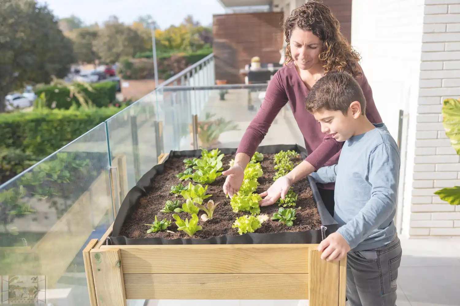 a woman and boy looking at plants on a balcony